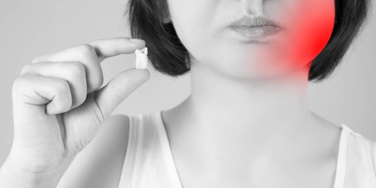 black and white stock photo of woman showing tooth between two fingers. Woman's cheek is highlighted red to show pain area.